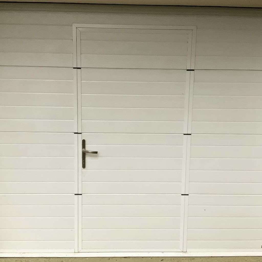 Porte de garage sur-mesure motorisée avec porte de passage intégrée